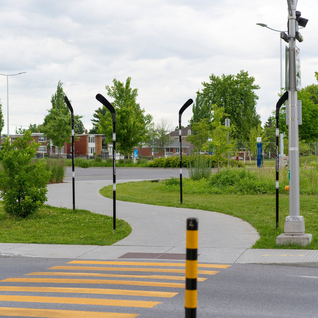 bollards rigides réparables personnalisés en bâtons de hockey noir et blanc devant l'arena de Granby