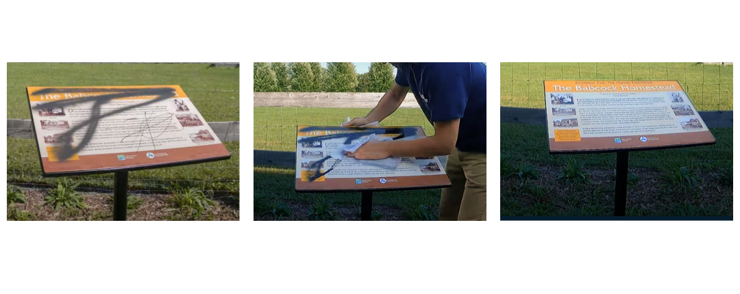 Someone removing a graffiti from a sign